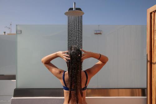 a woman is in a bathtub with her hair at "Makava Suites" Your Luxe Urban Sanctuary in Naxos Chora