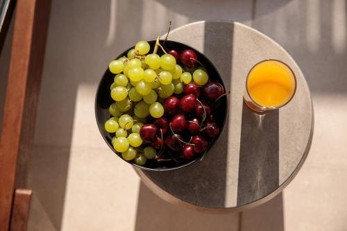 a bowl of fruit on a table with a glass at "Makava Suites" Your Luxe Urban Sanctuary in Naxos Chora