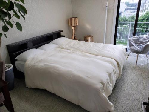 1 cama blanca grande en un dormitorio con ventana en クエーキーセンス琵琶湖 quakysense biwako villa for 4 to 8 people and family by Biwako Lake en Kido