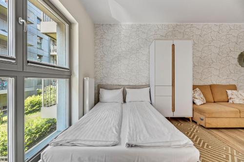 a bedroom with a large bed and a couch at GRANO APARTMENTS Gdańsk Old Town SPA & Wellness - GRANO APARTMENTS Gdańsk Residence SPA & Wellness in Gdańsk