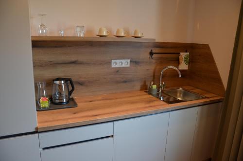 a kitchen with a sink and a wooden counter top at FloraVilla in Rajecké Teplice
