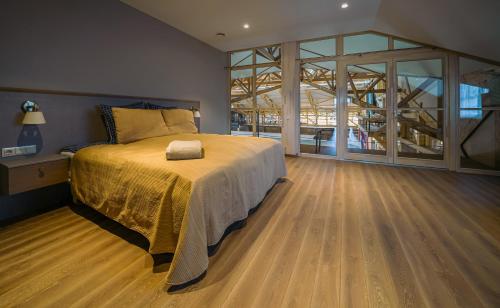 een slaapkamer met een bed en een groot raam bij Royal Horse Resort 