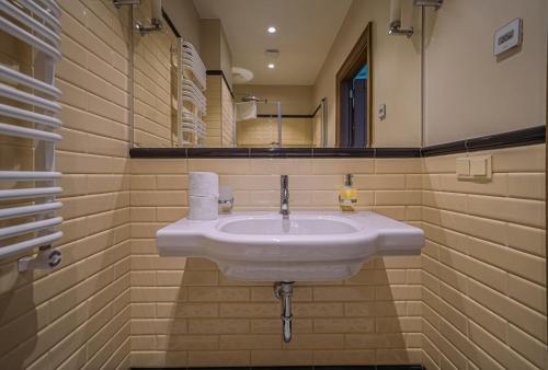 een badkamer met een witte wastafel en een spiegel bij Royal Horse Resort 