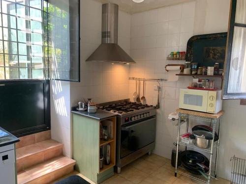 uma pequena cozinha com fogão e micro-ondas em Chalet con piscina privada em Blanca