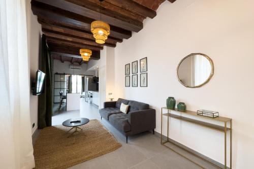 ein Wohnzimmer mit einem Sofa und einem Spiegel in der Unterkunft Fabulous One bedroom Apartament in Poble nou in Barcelona