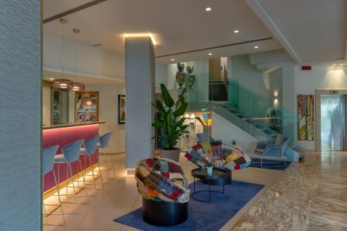 a lobby with chairs and a table in a building at Olivi Hotel & Natural Spa in Sirmione