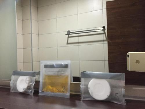 three urinals in a public restroom with plastic containers at Hotel Oaza in Konjic