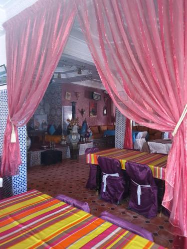 duas camas num quarto com cortinas cor-de-rosa em Will Center Assounfou em Tiznit