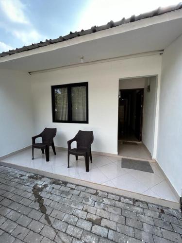 two chairs sitting on the outside of a white house at The Segaran House ONLY Syariah Unmarried Couple Not Allowed in Jakarta