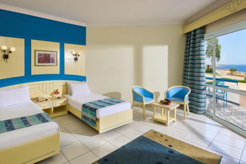 a hotel room with two beds and a balcony at Dreams Beach Resort - Sharm El Sheikh in Sharm El Sheikh