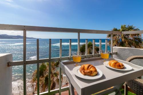two plates of croissants on a table on a balcony with the ocean at Over the Sea Los Lisos in Las Palmas de Gran Canaria