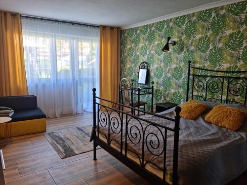 a bedroom with a bed and a green wall at Apartament i domki wakacyjne w uroczym zakątku Ustki in Ustka