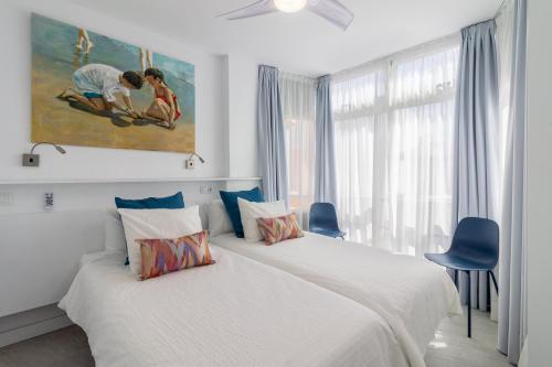 a bedroom with two beds and a painting on the wall at Over the Sea Los Lisos in Las Palmas de Gran Canaria