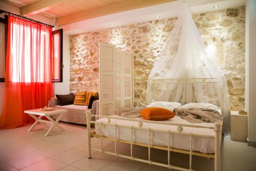 sypialnia z łóżkiem z baldachimem i kanapą w obiekcie AC Homes Christos w Retimnie
