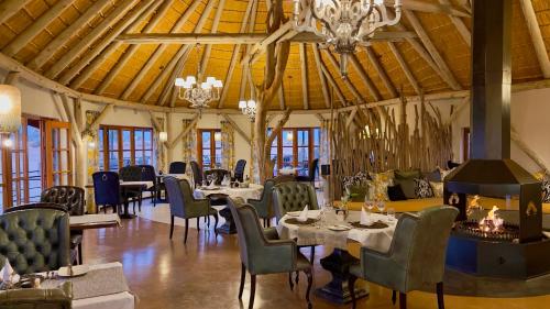 a dining room with tables and chairs and a chandelier at Kalahari Red Dunes Lodge in Kalkrand