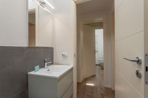 een badkamer met een witte wastafel en een spiegel bij Piazza Dei Rossi Due View in Florence