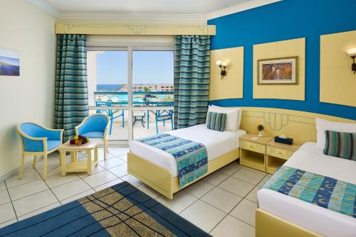 a hotel room with two beds and a balcony at Dreams Beach Resort - Sharm El Sheikh in Sharm El Sheikh