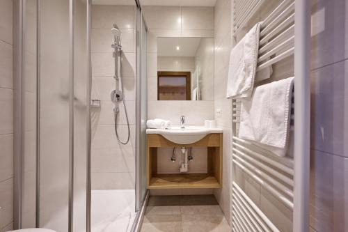 La salle de bains est pourvue d'un lavabo et d'une douche. dans l'établissement Landhaus Huber, à Altenmarkt im Pongau