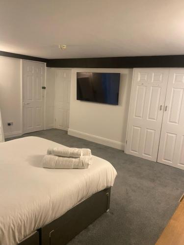 a bedroom with a bed and a flat screen tv at The Mariners Hotel in Lyme Regis