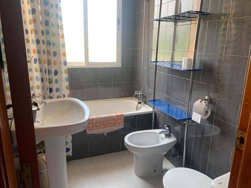 uma casa de banho com um lavatório, um WC e uma banheira em Piso vacacional con piscina en Benicassim em Benicàssim