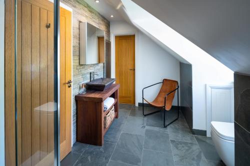 baño con escritorio y silla en una casa en The Retreat en Llechryd