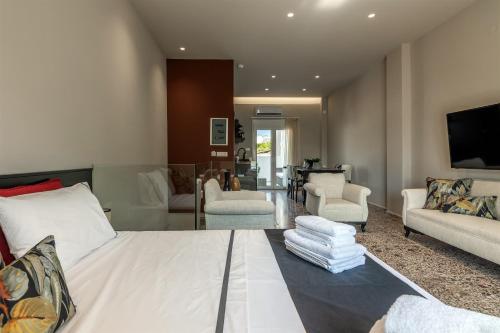 sala de estar con cama blanca y sala de estar en Andrews Luxury Suites Near The Airport, en Heraclión