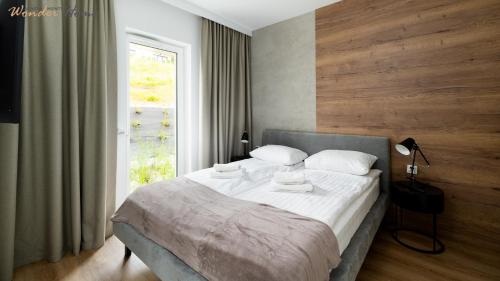 a bedroom with a large bed with a window at Wonder Home - Domki Hillside tuż przy stoku narciarskim - na terenie kompleksu plac zabaw i zewnętrzna siłownia, sklep, parking in Karpacz
