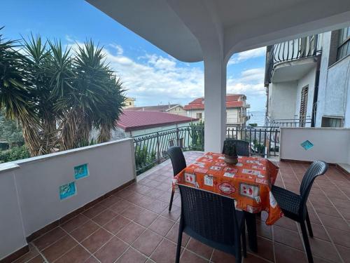 a patio with a table and chairs on a balcony at Casa Vacanza Riviera dei Saraceni in Trebisacce