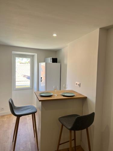 une cuisine avec deux tabourets et un comptoir avec deux chaises dans l'établissement Studio Neuf CentreVille Climatisé #13, à Toulon
