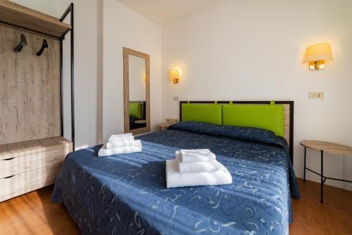 カットーリカにあるHotel Royalのベッドルーム1室(青いベッド1台、白いタオル2枚付)