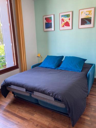 - une chambre avec un lit doté de draps bleus et une fenêtre dans l'établissement Studio Cosy, Lumineux et Bien situé., à Lorient
