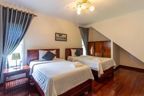 sypialnia z 2 łóżkami i oknem w obiekcie Residence 22 w Siem Reap