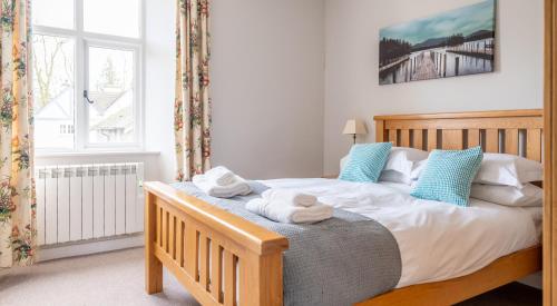 a bedroom with a bed with towels on it at Briar Cottage in Rusland