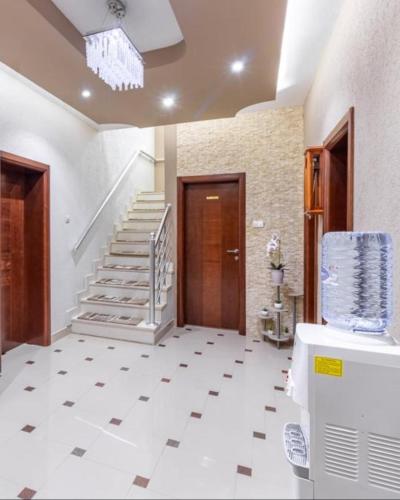 a hallway with a white tile floor and stairs at Apart-Hotel President in Ulcinj