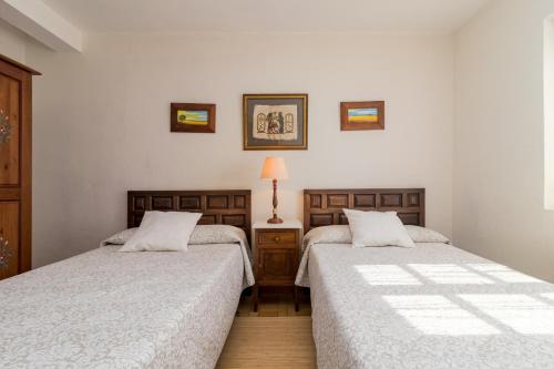 dos camas sentadas una al lado de la otra en un dormitorio en La Casa de Mamasita (Casa completa), en Queveda