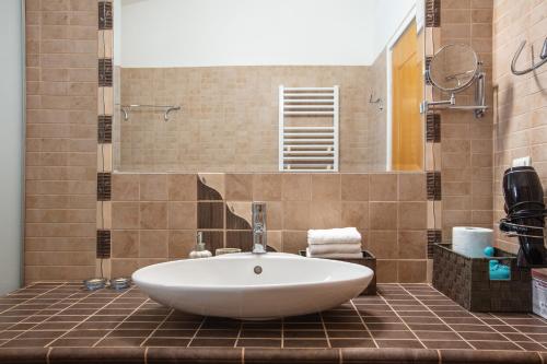 a bathroom with a large white tub in a tiled bathroom at Villa Elesia in Koxaré