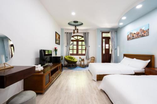 a hotel room with two beds and a desk at The Lovenote Home in Ho Chi Minh City