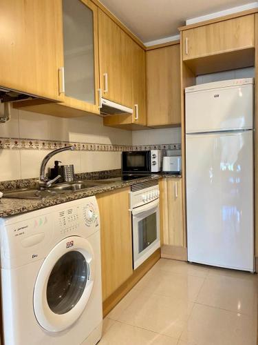 Il comprend une cuisine équipée d'un lave-linge et d'un lave-vaisselle blanc. dans l'établissement Andainas Apartamentos Turísticos A, à O Milladoiro