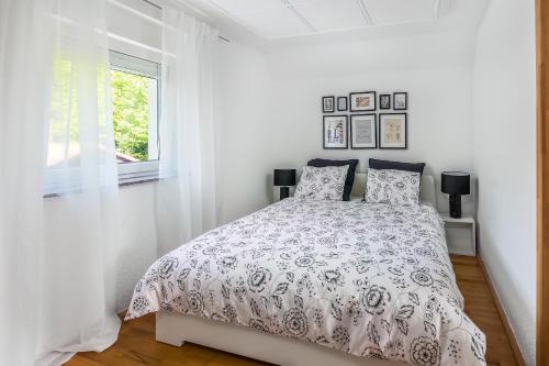 a white bedroom with a bed and a window at Villa Tratea - with a heated pool in Tomić Draga
