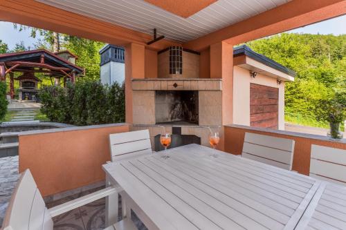 a outdoor table with two glasses of wine on a patio at Villa Tratea - with a heated pool in Tomić Draga