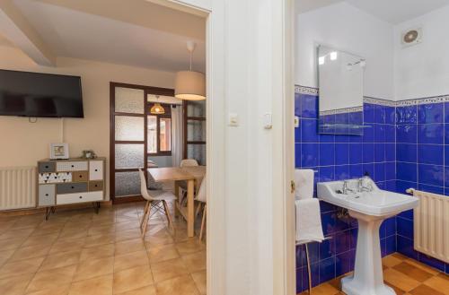 a blue tiled bathroom with a sink and a table at La Casa de Mamasita (Casa completa) in Queveda