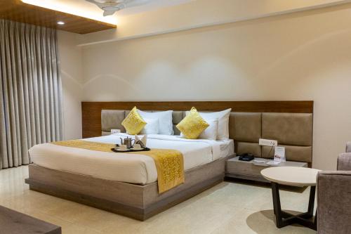 pokój hotelowy z łóżkiem i stołem w obiekcie CENTRAL A BOUTIQUE HOTEL w mieście Belagavi