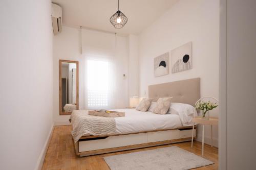 een witte slaapkamer met een bed en een spiegel bij Perfect one bedroom apartment in Madrid