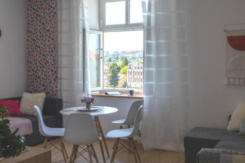 a living room with a table and chairs and a window at Studio z widokiem na rzekę in Przemyśl