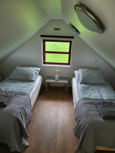 two beds in a room with a window at Hólar countryside cabin 1 in Selfoss