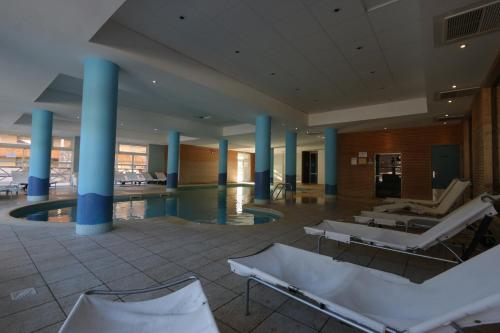 eine große Lobby mit Stühlen und einem Pool in der Unterkunft Terrasses de Labrau - Res piscine in Allos