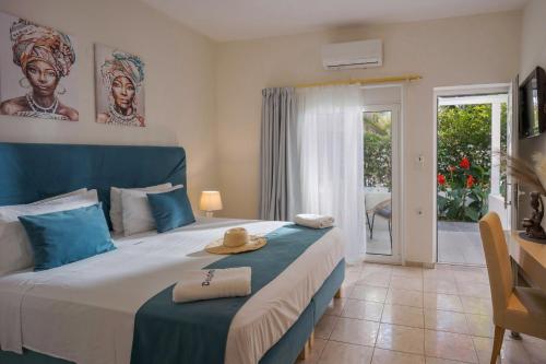 a bedroom with a bed with a blue headboard at Despina Aparthotel by Philoxenia Hotel & SPA in Malia