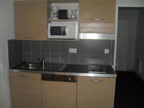 a kitchen with a sink and a microwave at Terrasses de Labrau - piscine in Allos