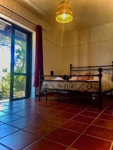 sypialnia z łóżkiem i dużym oknem w obiekcie Appartamento Villa Sarda Jamelia w mieście Elmas