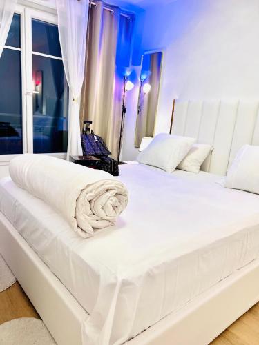 two large white beds in a room with a window at LES RÉSIDENCES DE DJIBRIL in Le Blanc-Mesnil